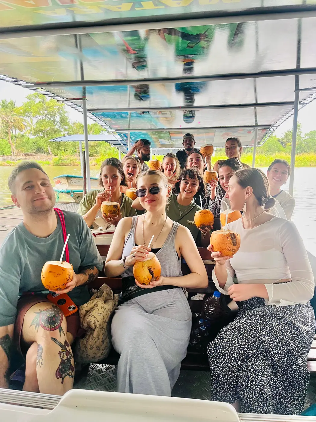 Guests posing with king coconuts on the crocodile-watching boat