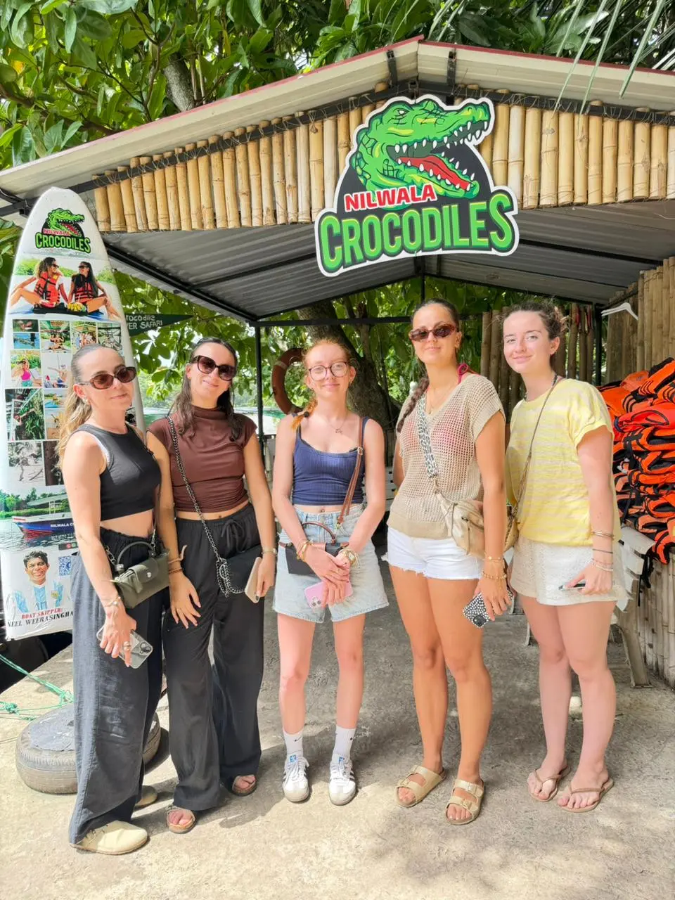 Guests posing beneath the Nilwala Crocodiles sign before their safari